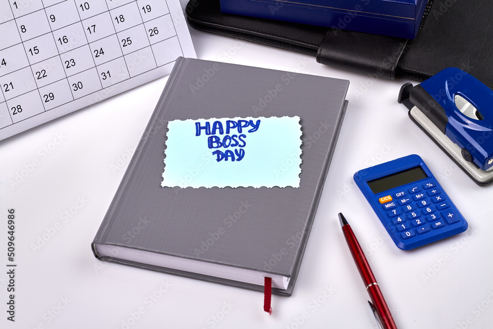 Happy boss day greeting on the book on white background. Office workspace top view. Happy boss day greeting on the book on white background. Office workspace top view.