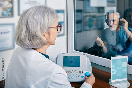 Senior man getting hearing test at audiology center. Audiometry, hearing check-up photo