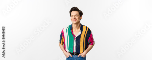 Image of handsome young man in colored summer shirt looking happy, standing over white background