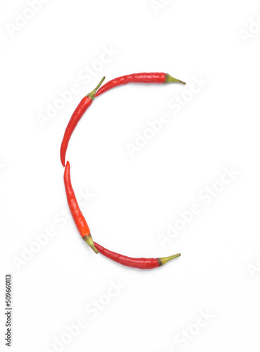 Letter C made from red chilli peppers isolated on white background