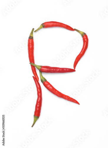 Letter R made from red chilli peppers isolated on white background