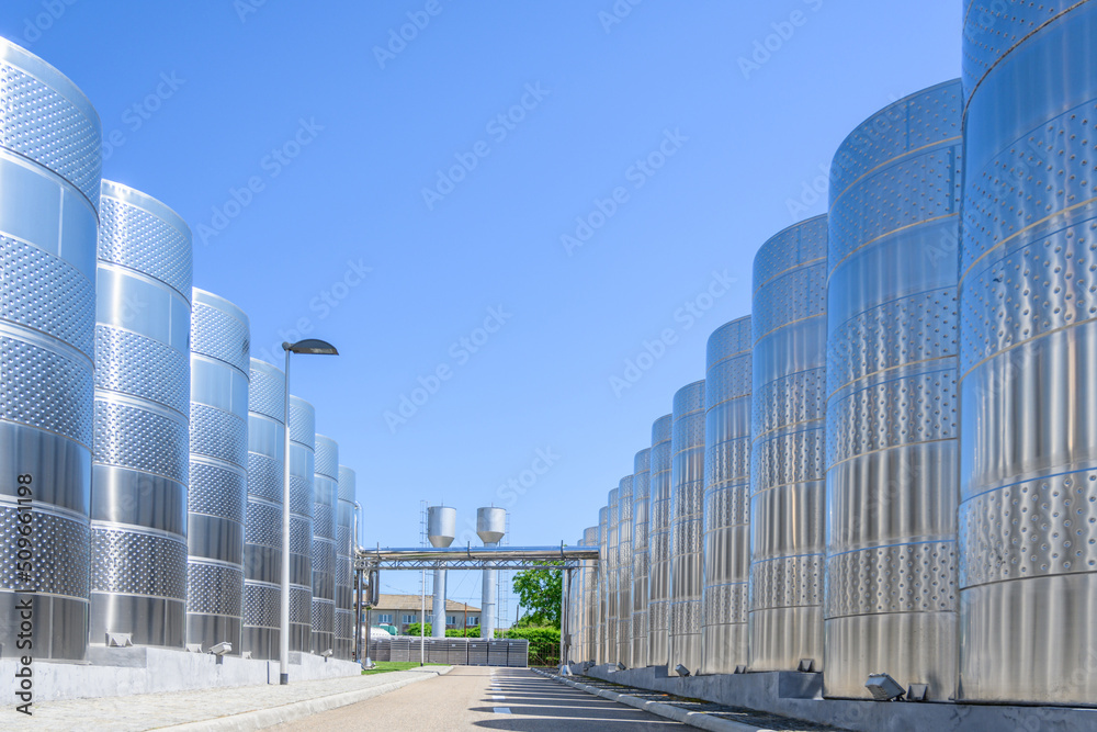 Fototapeta premium Wine steel tanks, equipment of contemporary winemaker factory. Barrels for wine storage. Equipment for the fermentation, distillation of alcohol. Preparation workshop for pure alcohols.