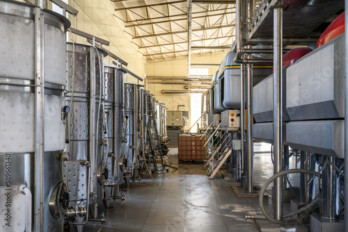 Wine steel tanks, equipment of contemporary winemaker factory. Barrels for wine storage. Equipment for the fermentation, distillation of alcohol. Preparation workshop for pure alcohols.
