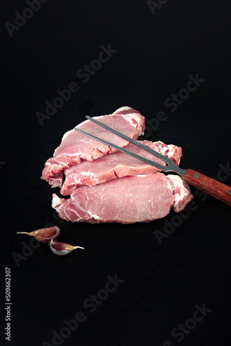 Raw veal meat fillet for grilling with meat fork on dark background, Tenderloin fillet mignon.