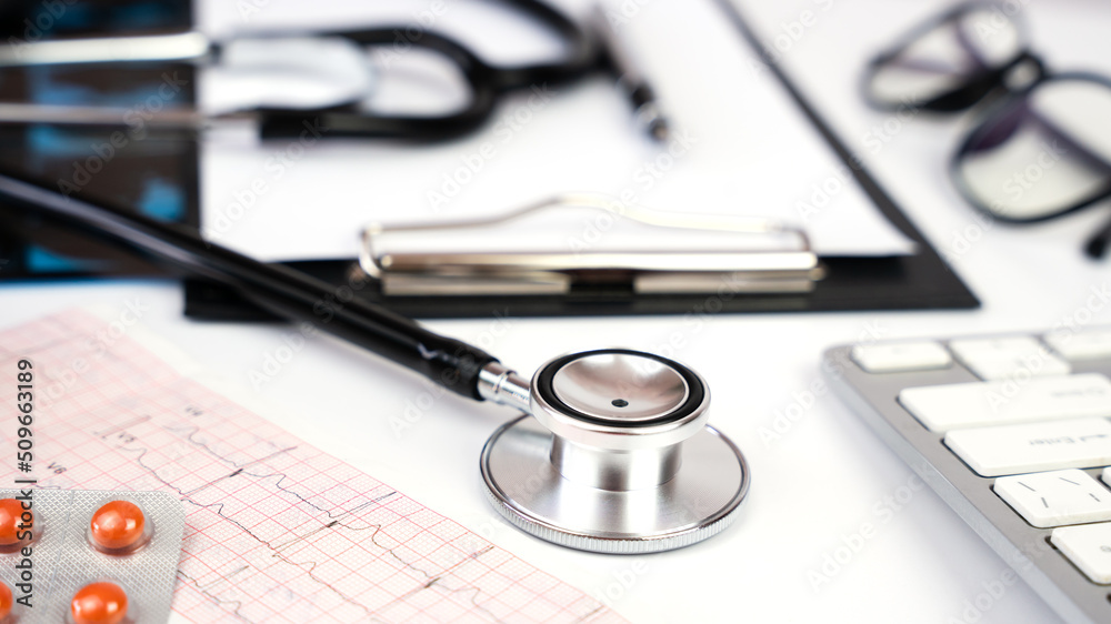 Banner. Doctor's workplace with stethoscope, clipboard and glasses. Close-up. Selective focus. Banner. Doctor's workplace with stethoscope, clipboard and glasses. Close-up. Selective focus.