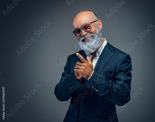Billede på lærred Shot of happy elderly businessperson with beard and sunglasses dressed in stylish suit