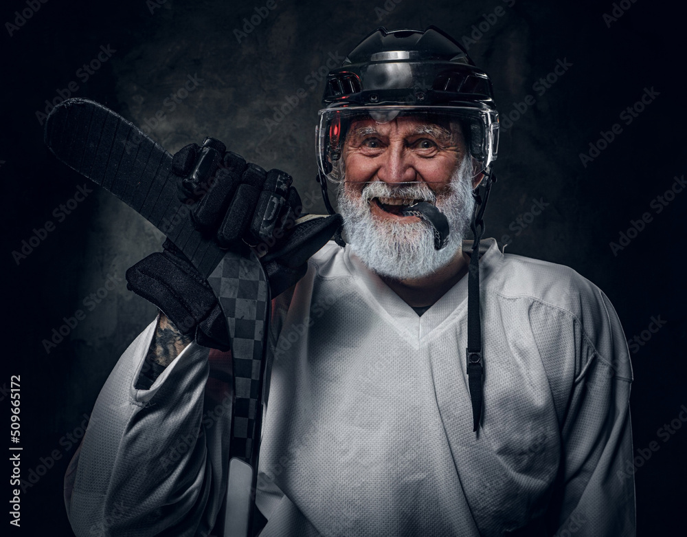 Studio shot of happy gray haired grandfather hockey player dressed in white sportswear. Studio shot of happy gray haired grandfather hockey player dressed in white sportswear.