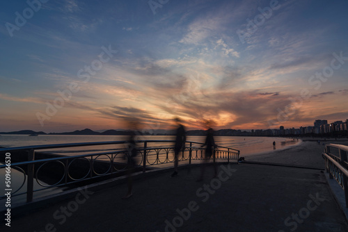 Santos, Brazil. Sunset on the bridge of water channel nº6 on the beach. Figures of people passing by and silhouettes. © Stefan Lambauer