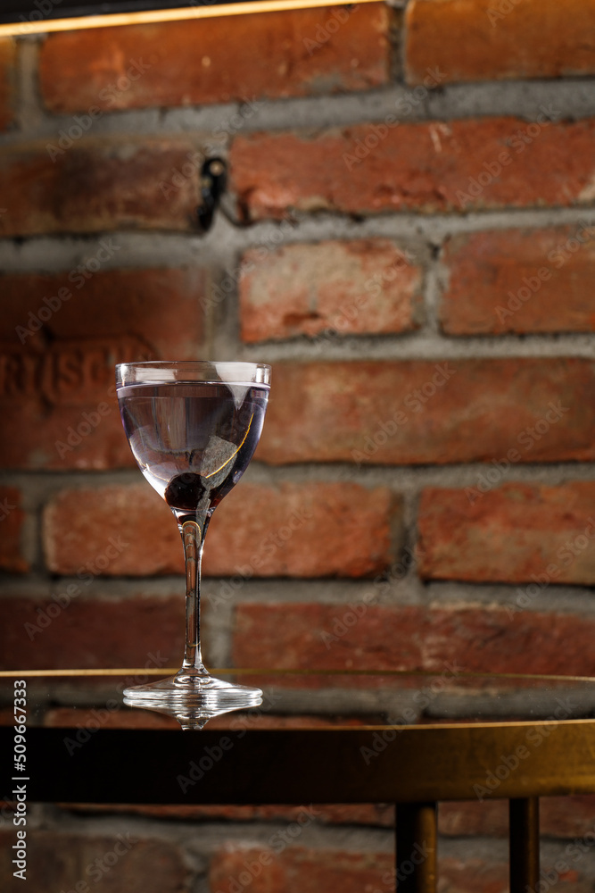 Aviation, drink with gin, lemon juice, maraschino liqueur and violet cream liqueur standing on bar counter.