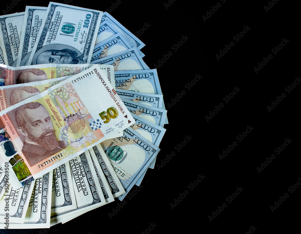 One hundred dollars in a large amount and in the center 50 Bulgarian lev on a black background One hundred dollars in a large amount and in the center 50 Bulgarian lev on a black background