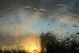 Landschaft mit Sonnenuntergang und blauem Himmel hinter Glasscheibe mit Regentropfen bei Wind und Regen am Abend im Frühling 