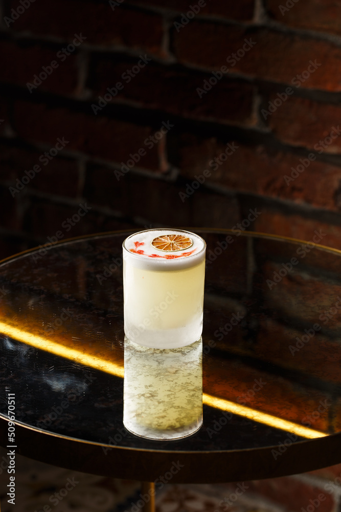 Pisco sour cocktail - whiskey with lime, egg white, sugar syrup in glass on dark background. Space for text