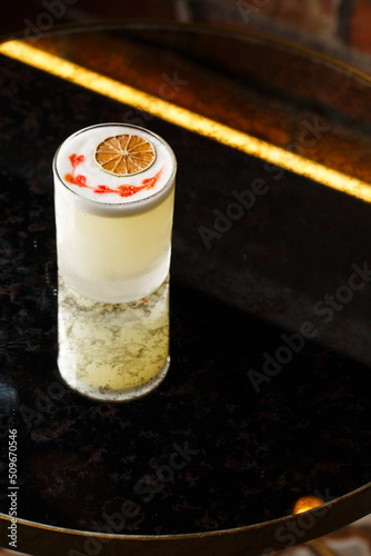 Obraz na płótnie Pisco sour cocktail - whiskey with lime, egg white, sugar syrup in glass on dark background. Space for text w salonie