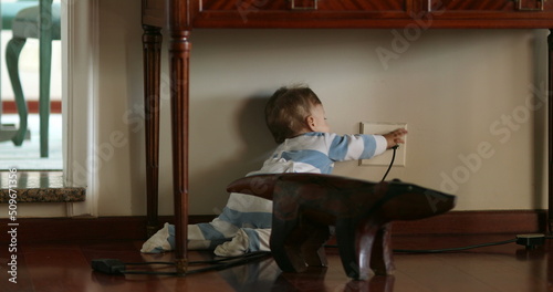 Photography Baby infant on hardwood floor at home crawling and reaching to electrical outlet