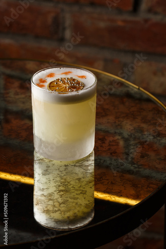 Obraz na płótnie Pisco sour cocktail - whiskey with lime, egg white, sugar syrup in glass on dark background. Space for text w salonie