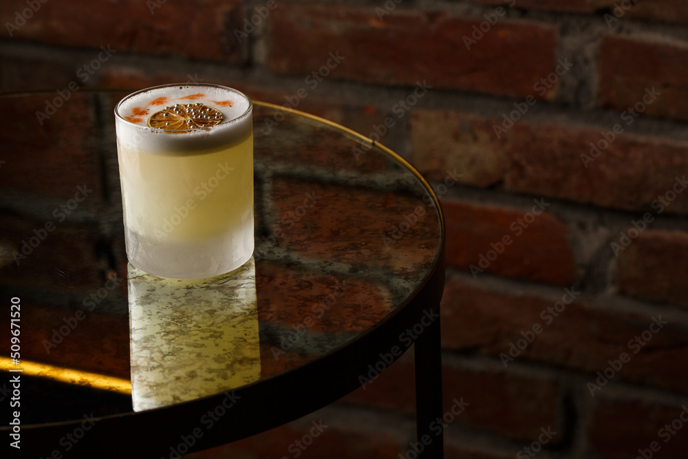 Pisco sour cocktail - whiskey with lime, egg white, sugar syrup in glass on dark background. Space for text