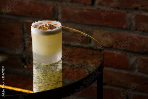 Pisco sour cocktail - whiskey with lime, egg white, sugar syrup in glass on dark background. Space for text