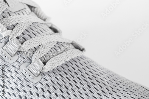 New unbranded running sneaker or trainer on white background. Men s light grai sport footwear. Close-up of a pair sneakers or sport shoes.