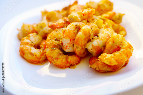 Fried large peeled shrimp with spices on a white plate