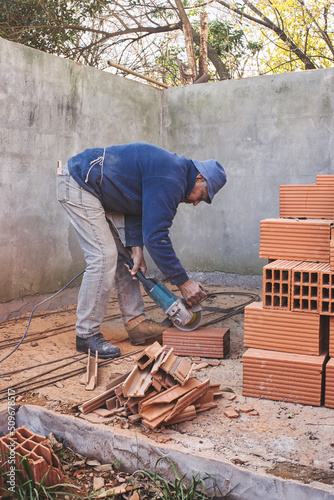 Crouching man preparing the brick cut