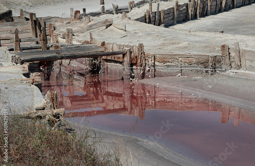 деревянные укрепления и мостики на соляных розовых озерах.Розовая водная гладь озер выпаренных из морской воды