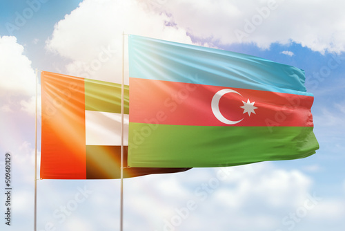 Sunny blue sky and flags of azerbaijan and uae