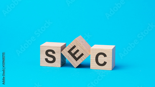 sec text on wooden blocks, business concept, blue background photo