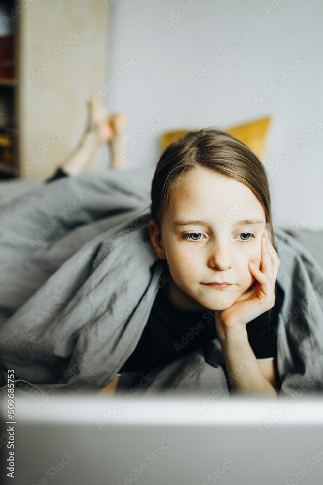 A girl studies at a laptop at home In the bed A girl studies at a laptop at home In the bed