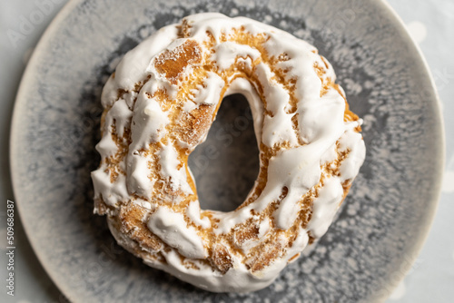 Airy cookies, decorated with white meringues on, light background.Appetizing portuguese pastries on a plate