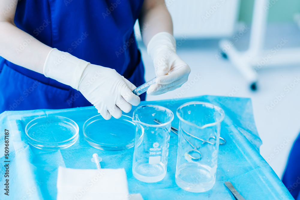 doctor's hands hold a syringe and empty test tubes, makes research in science. doctor's hands hold a syringe and empty test tubes, makes research in science.