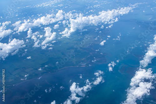 Aerial view of blue ocean and coast land with a few clouds