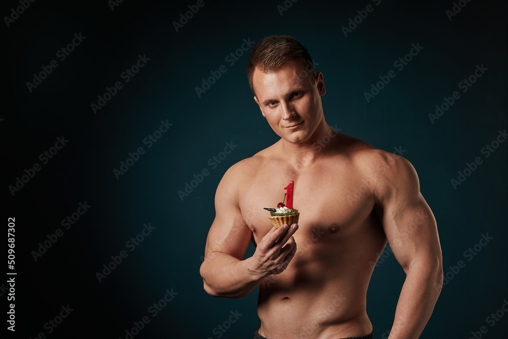 Fototapeta premium strong athletic man with cake celebrating birthday