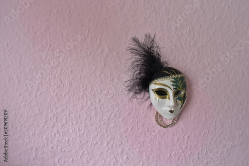 harlequin mask from venice on a pink wall, copy space, pastel colour © Lukas