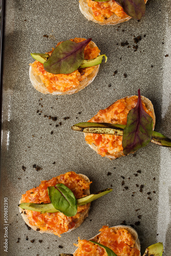 Obraz na płótnie baked bruschetta with salmon, cheese, sun-dried tomatoes and avocado in gray plate on bright background w salonie