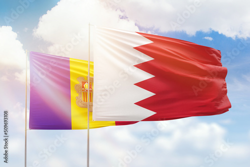 Sunny blue sky and flags of bahrain and andorra