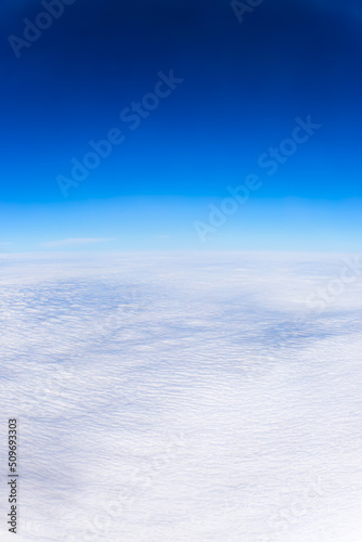 Blue Sky on top with white fluffy clouds on the bottom