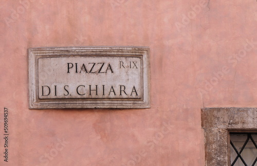 Pink Wall with Piazza di S. Chiara Street Sign Close Up in Rome, Italy © Monica