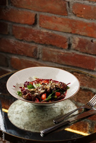 Obraz na płótnie Salad with veal and tomatoes. Beef steak with raw vegetables mix side view. Grilled meat with garnish close-up. Delicious main course on table w salonie