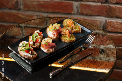 Obraz na płótnie Bruschettas with vegetables. Start dishes with cherry tomatoes, avocado, cream cheese and shrimps. Food composition, tasty italian meal w salonie