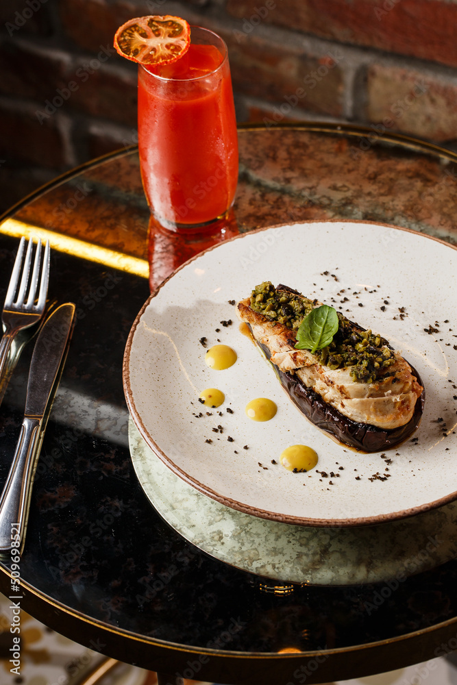 Baked eggplant stuffed with grilled chicken, tomatoes and spices on white plate. Traditional dish Karniyarik of turkish cuisine. View from above
