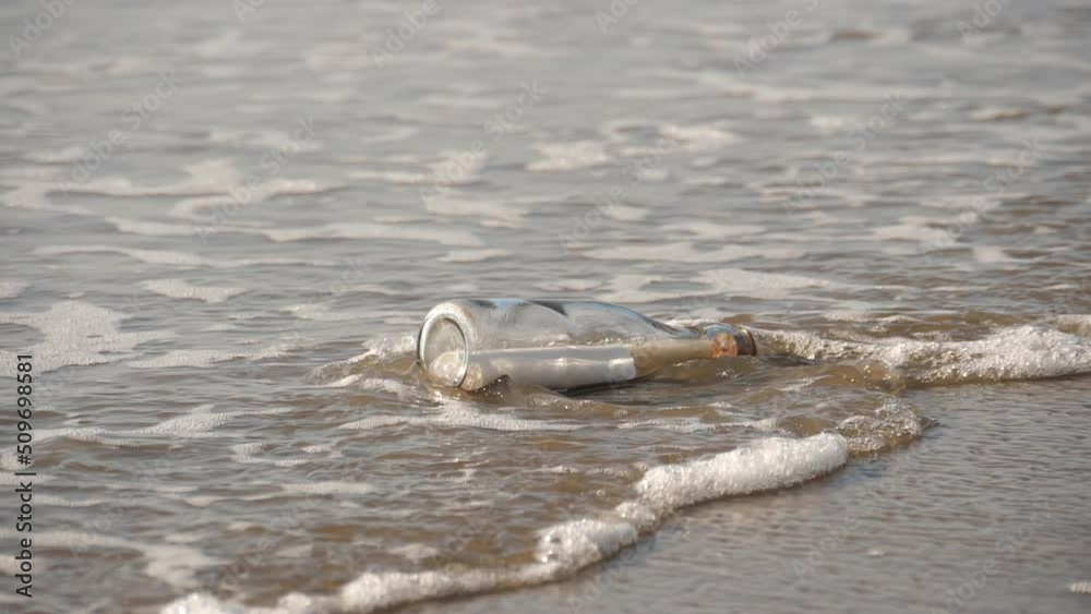 A message in a bottle washed up on the beach by waves