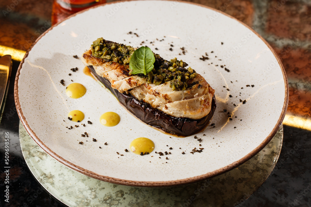 Baked eggplant stuffed with grilled chicken, tomatoes and spices on white plate. Traditional dish Karniyarik of turkish cuisine. View from above