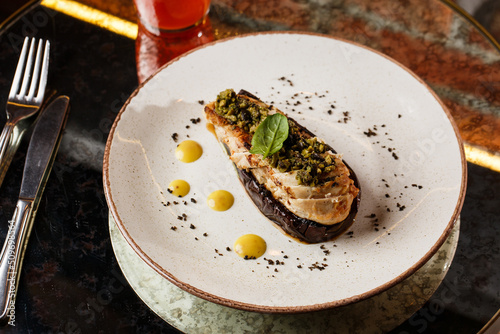 Baked eggplant stuffed with grilled chicken, tomatoes and spices on white plate. Traditional dish Karniyarik of turkish cuisine. View from above