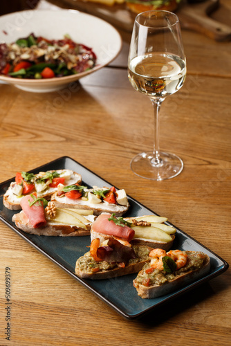 Obraz na płótnie Bruschettas with vegetables. Start dishes with cherry tomatoes, avocado, cream cheese and shrimps. Food composition, tasty italian meal w salonie