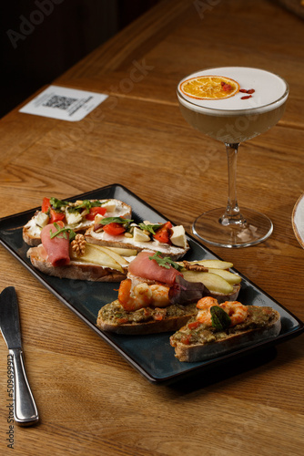 Obraz na płótnie Bruschettas with vegetables. Start dishes with cherry tomatoes, avocado, cream cheese and shrimps. Food composition, tasty italian meal w salonie