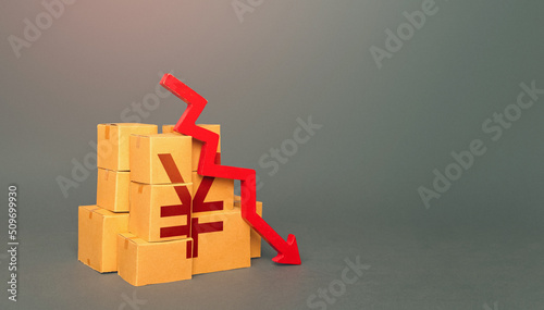 Boxes with yuan or yen symbol and down arrow. Fall in the production of goods. Worsening trade. Embargo, sanctions. Low consumption. Economic slowdown. Price reduction. Decrease in stocks of products. photo