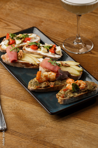 Obraz na płótnie Bruschettas with vegetables. Start dishes with cherry tomatoes, avocado, cream cheese and shrimps. Food composition, tasty italian meal w salonie