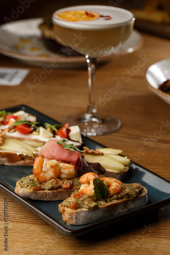 Obraz na płótnie Bruschettas with vegetables. Start dishes with cherry tomatoes, avocado, cream cheese and shrimps. Food composition, tasty italian meal w salonie