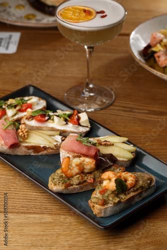 Obraz na płótnie Bruschettas with vegetables. Start dishes with cherry tomatoes, avocado, cream cheese and shrimps. Food composition, tasty italian meal w salonie