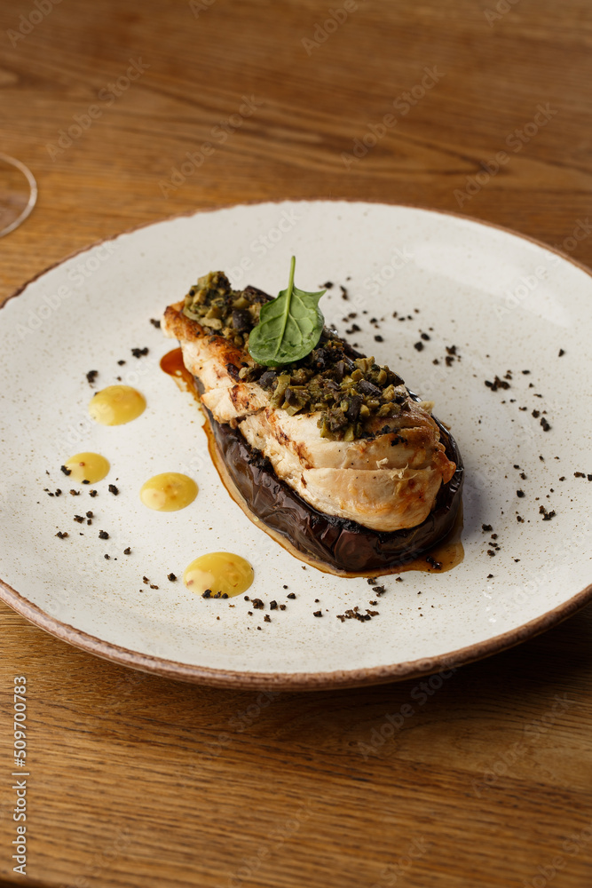 Baked eggplant stuffed with grilled chicken, tomatoes and spices on white plate. Traditional dish Karniyarik of turkish cuisine. View from above